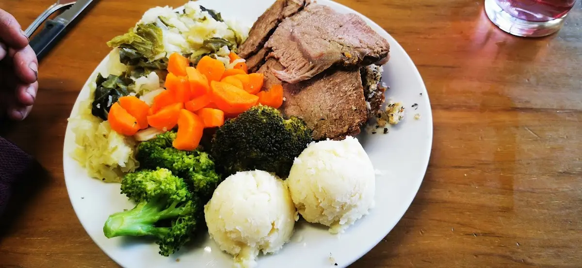 Roast beef dinner with mashed potatoes, carrots, broccoli, and cabbage